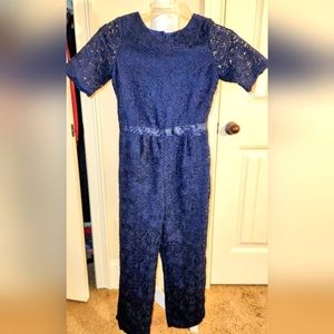 Janie and Jack lace jumpsuit with grossgrain ribbon bow and scalloped details.